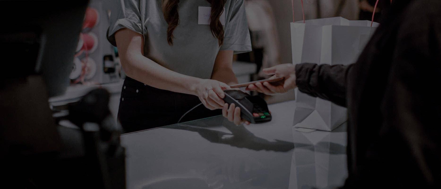 Person som betalar med sitt re:member kreditkort via mobilen i en butik.
